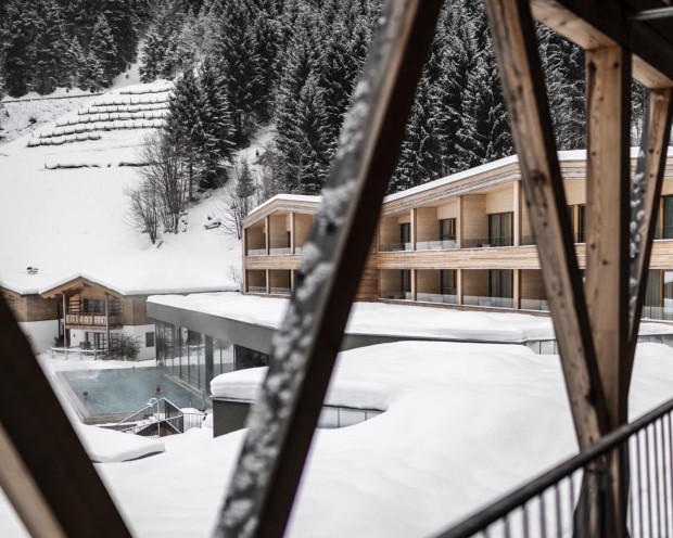 Blick auf den Outdoor Infinity Pool des Familienhotel Feuerstein im Winter
