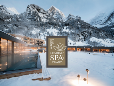 Der Außenpool des Feuersteins im Schnee und das Logo von Leading Spa Award Winner 2025.