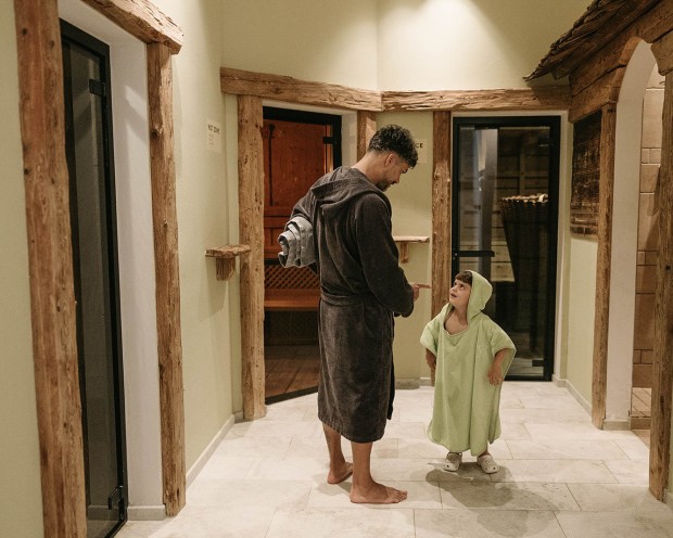 Vater mit Sohn im Familysauna im Familienhotel mit Wasserrutsche Feuerstein, in Südtirol.
