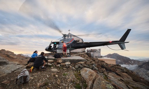 A helicopter lands at the Becherhaus with filming equipment.
