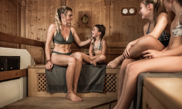 Mama genießt mit ihren Kindern eine gemeinsame Sauna in der Feuerstein Familien Sauna
