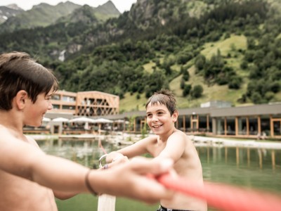 zwei Teenie Jungs spielem am Floß vom Schwimmsee