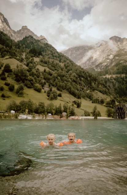 zwei Kinder spielen im Teich im familienhotel südtirol mit wasserrutsche