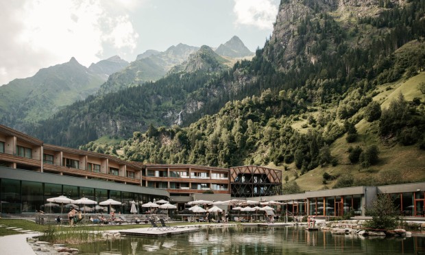 Der Schwimmsee mit Hotel und Bergen im Hintergrund.