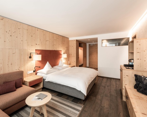 Ein Schlafzimmer mit Sofa und Fernseher im Kinderhotel Südtirols.