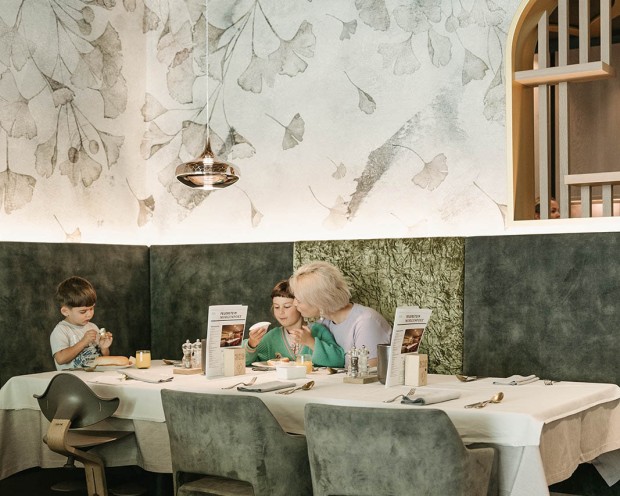 Eine Familie isst Frühstück in einen Kinderhotel Südtirols.