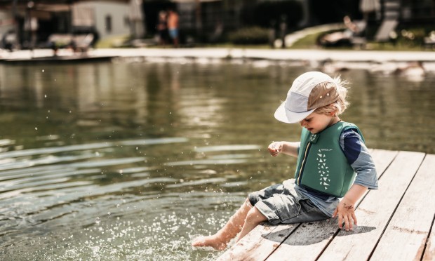Kleines Kind plantscht im Teich