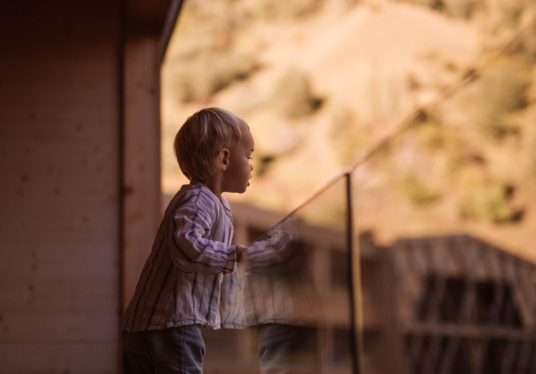 Small child looks from the balcony