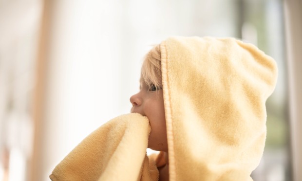 A toddler is wrapped in a cosy towel in the Feuerstein family wellness area.