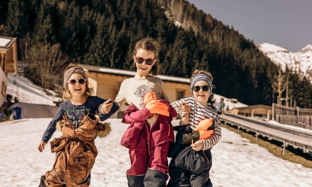 Kinder lachen und spielen im Schnee im Feuerstein Garten.