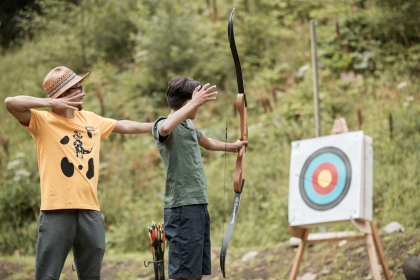 Betreuuer erklärt Teenager das Bogenschießen
