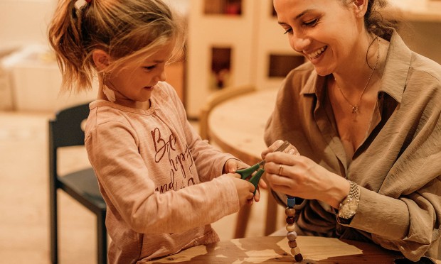 Kleines Mädchen schneidet etwas mit einer Schere  durch