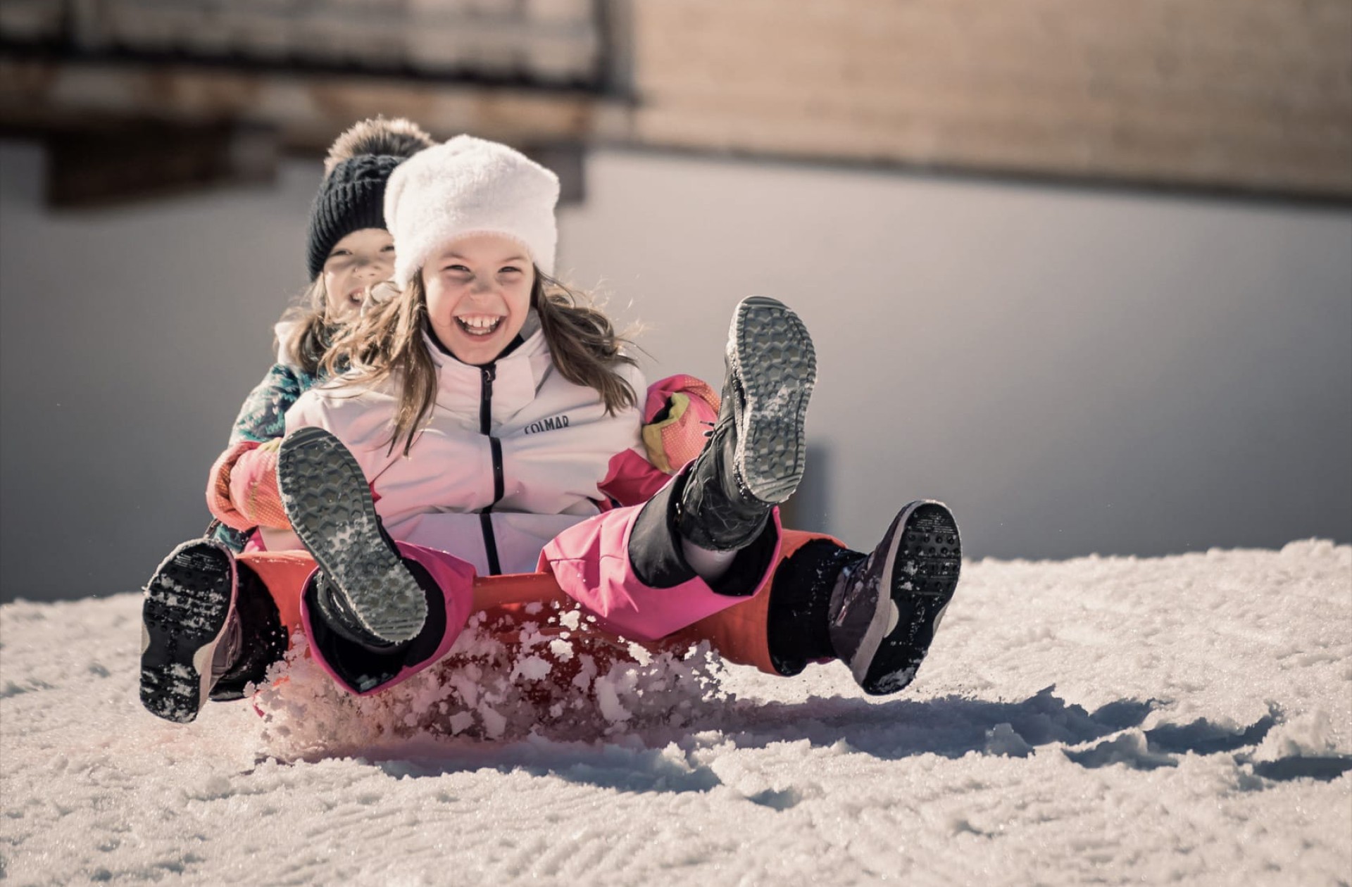 2 Kinder rutschen den Hügel hinunter