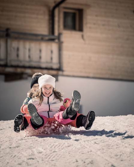 2 Kinder rutschen den Hügel hinunter