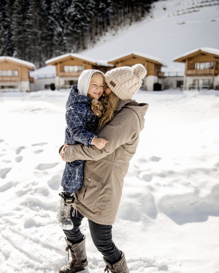 Kind hält Mutter im Arm und spazieren im Schnee