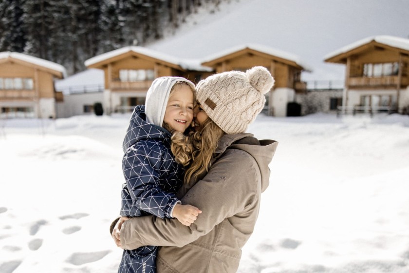 Kind hält Mutter im Arm und spazieren im Schnee