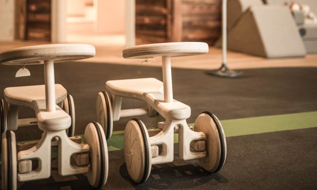 2 Holzautos vor ein begehbaren Puppenhaus