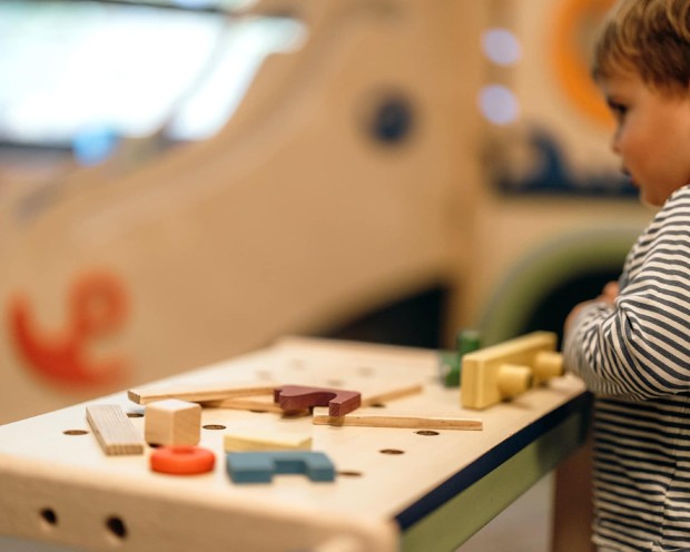 Kleines Kind spielt mit Holzspielzeug