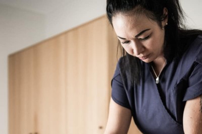 Terapista che massaggia la schiena di una donna sdraiata durante massaggio sportivo