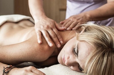 Der Rücken einer Frau wird massiert