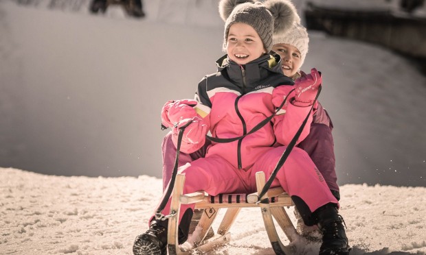2 Kinder auf einen Schlitten