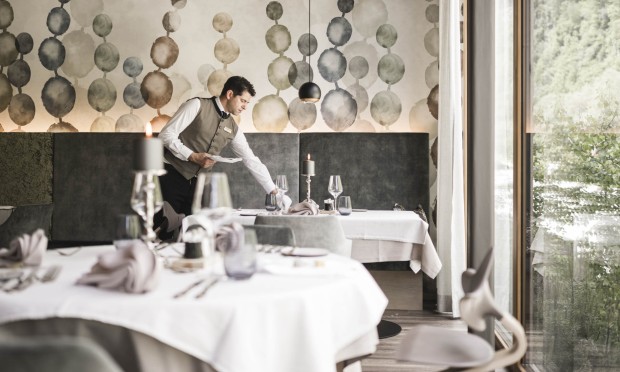 Ein eleganter Speisesaal mit gedeckten Tischen und modernem Wanddekor.