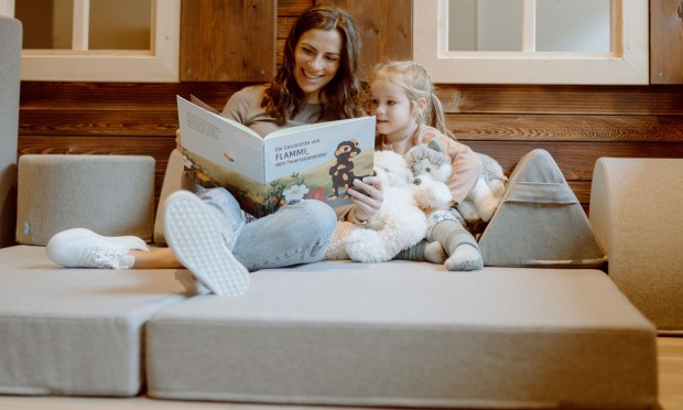 Ein gemütlicher Kinderbereich mit Matratzen und Kissen, in dem Kinder entspannt liegen.