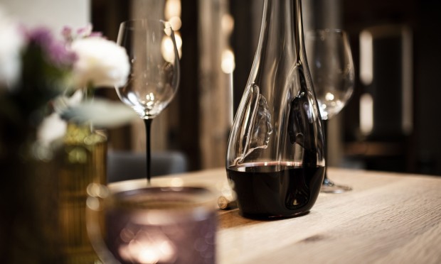 Eine Nahaufnahme von Weingläsern mit floraler Tischdekoration in einem Restaurant.