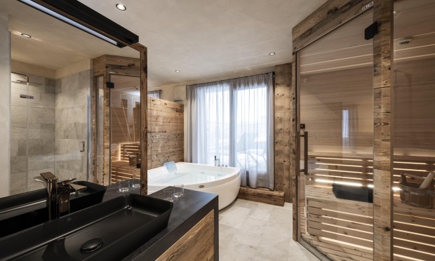 Ein luxuriöses Badezimmer mit Holzdetails, großer Badewanne und moderner Beleuchtung.