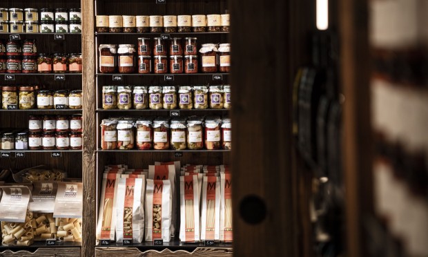 Ein Regal mit Feinkostprodukten und edlen Getränken in einem Bistro.