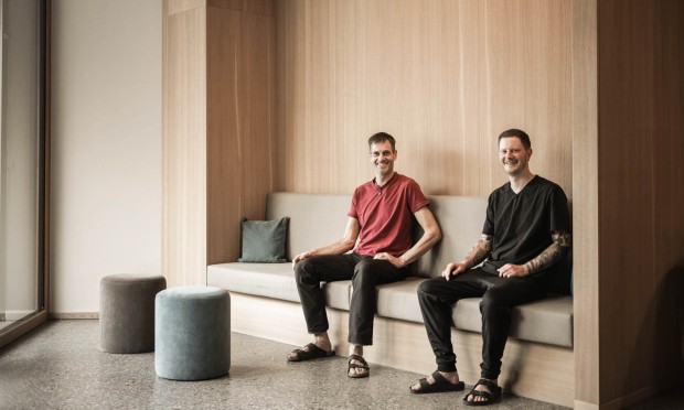 Zwei Männer sitzen entspannt in einem modernen Wellness-Warteraum.