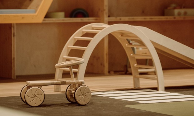 Ein stilvoller Kinderbereich mit Wabenwänden und Holzspielgeräten.