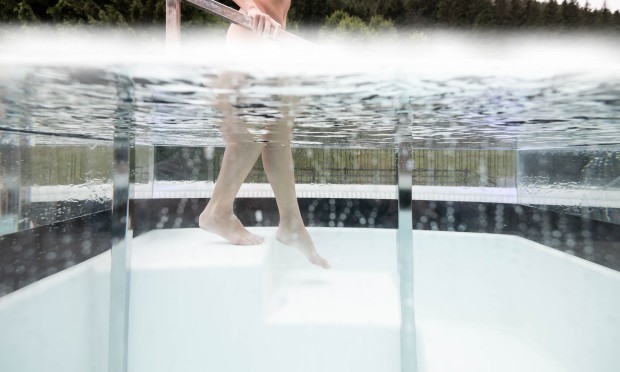 Woman slowly enters the ice pool on the roof terrace