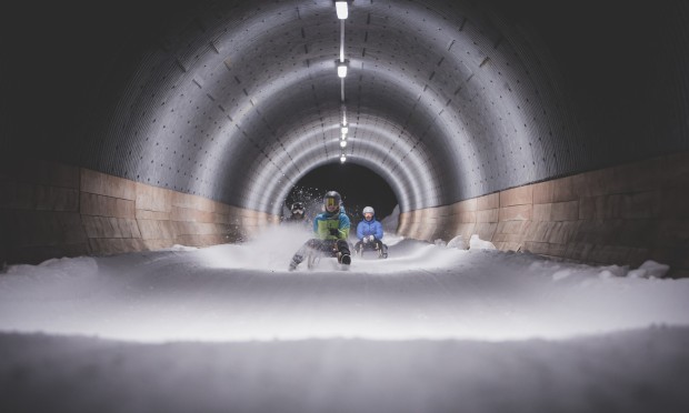 Nächtlicher Rodelspaß durch einen Tunnel in Schneelandschaft