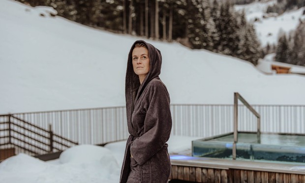 Woman in bathrobe on roof terrace in winter