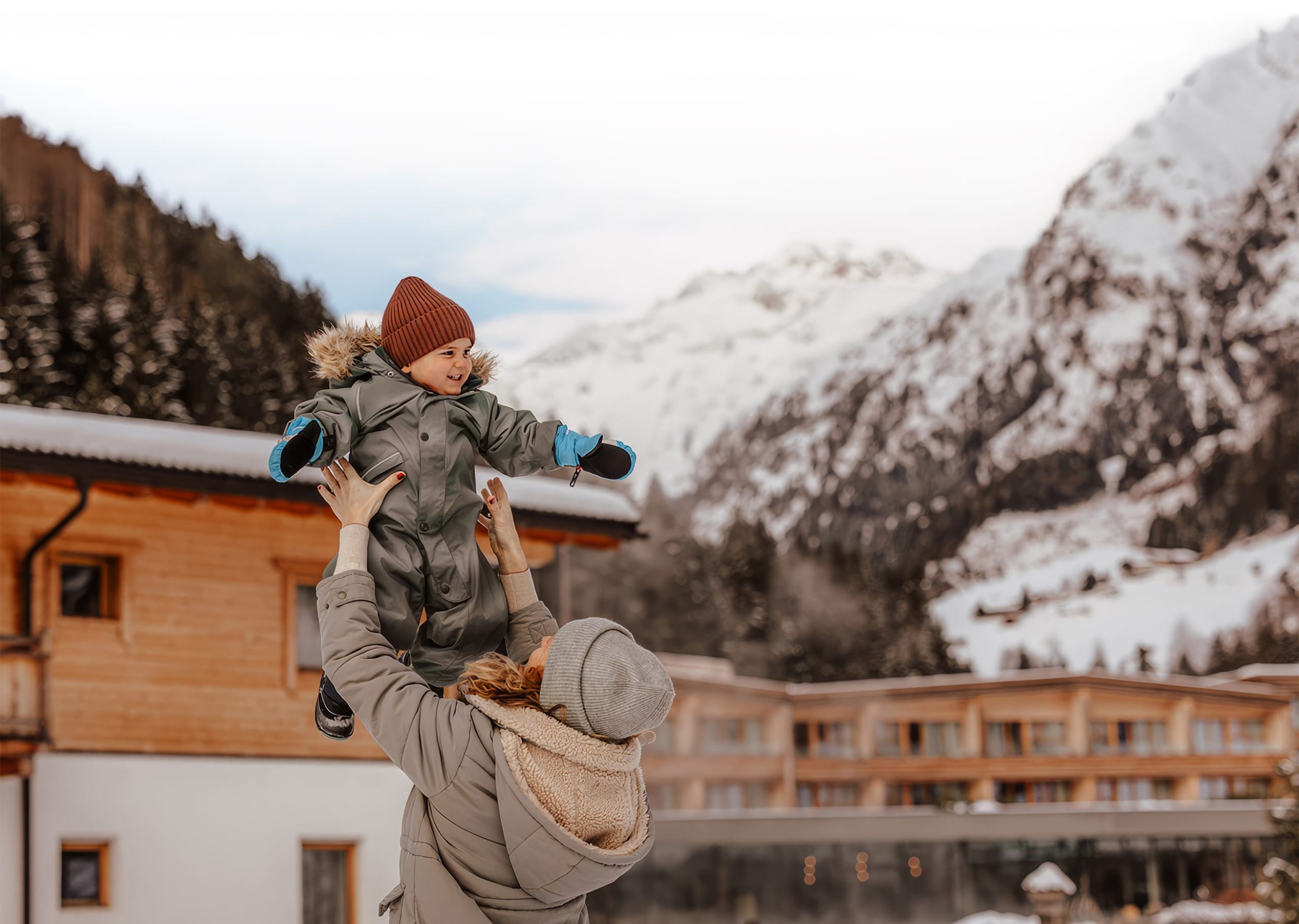 Mutter hält Kind hoch in die Luft