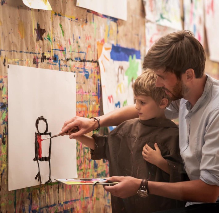 Kind malt mit Vater im Malatellier
