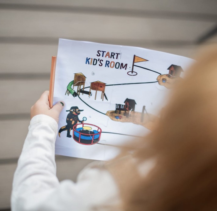 Kind hält gemalenes Bild vom Kids Room