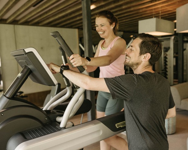 Eine Frau trainiert mit einen Trainer auf der Laufbahn im Wellness Familienhotel Südtirols.