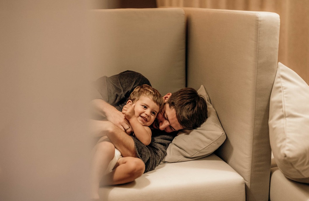 Vater und Sohn kuscheln im Ruhebereich im Wellness Familienhotel Südtirol.