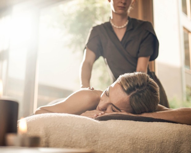 Eine Frau geniesst ihre Rückenmassage im Wellness Familienhotel in Südtirol.