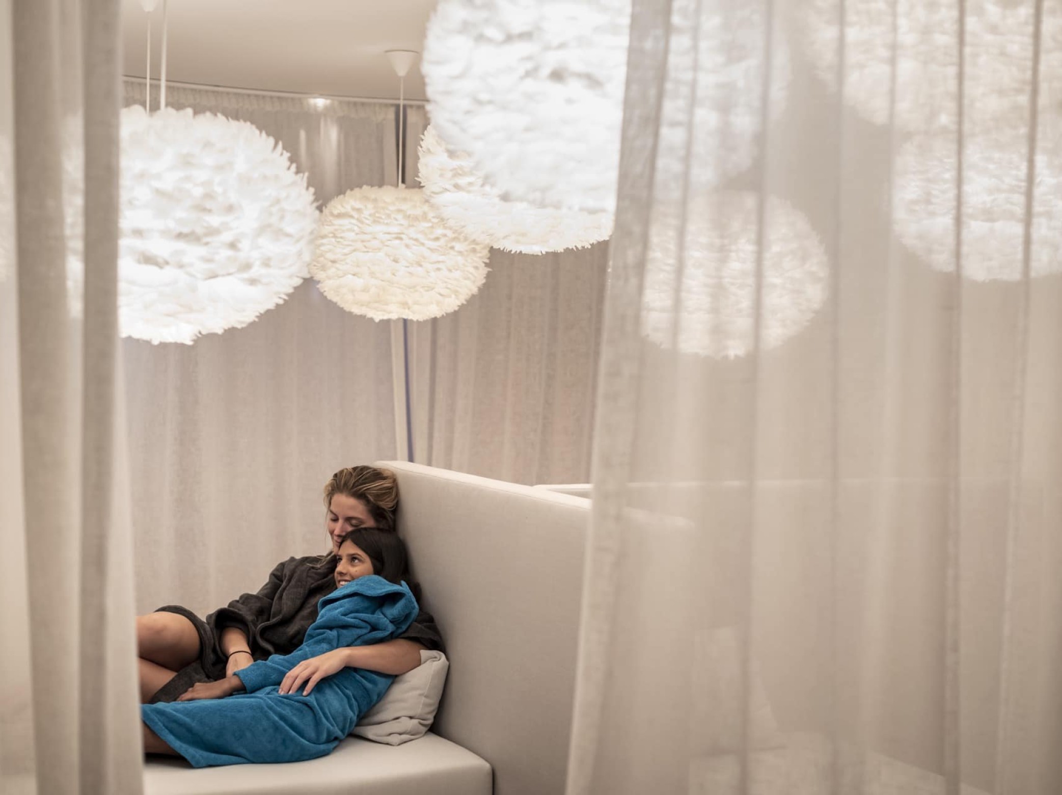 Mutter und Tochter kuscheln im Ruhebereich im Wellness Familienhotel Südtirol.