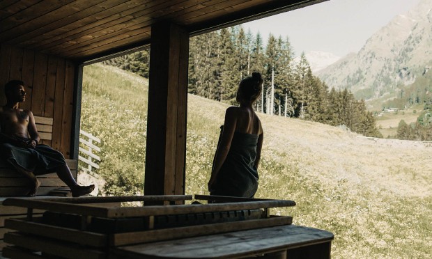 Eine Person genießt die Aussicht aus einem großen Fenster auf die Natur.