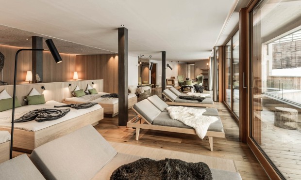 Ein luxuriöser Wellnessbereich mit großen Fenstern und modernen Liegen.