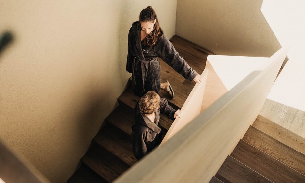 Eine Person steigt eine moderne Holztreppe in einem Spa-Bereich hinauf.