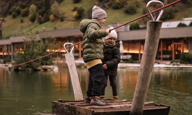 Kinder fahren mit dem Floß über den Feuerstein Schwimmteich - Herbstliche Stimmung