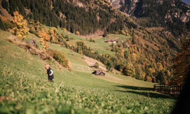 ein Kind geht über die herbstliche Wiese spazieren