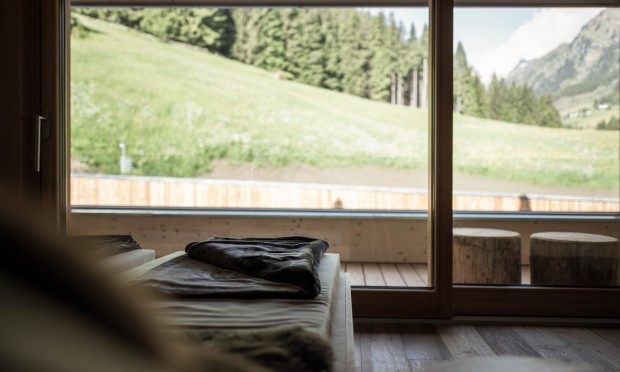 Eine gemütliche Spa-Liege mit Blick auf eine grüne Almwiese.