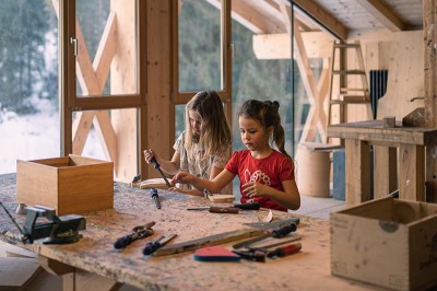 Kinder werkeln mit Holz in der Holzwerkstatt im Familienhotel Feuerstein in Südtirol