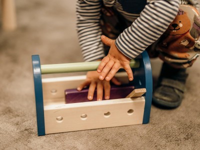 Kleiner Junge spielt mit Holzspielzeug